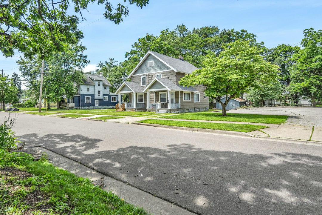 Blue craftsman home on a tree-lined street