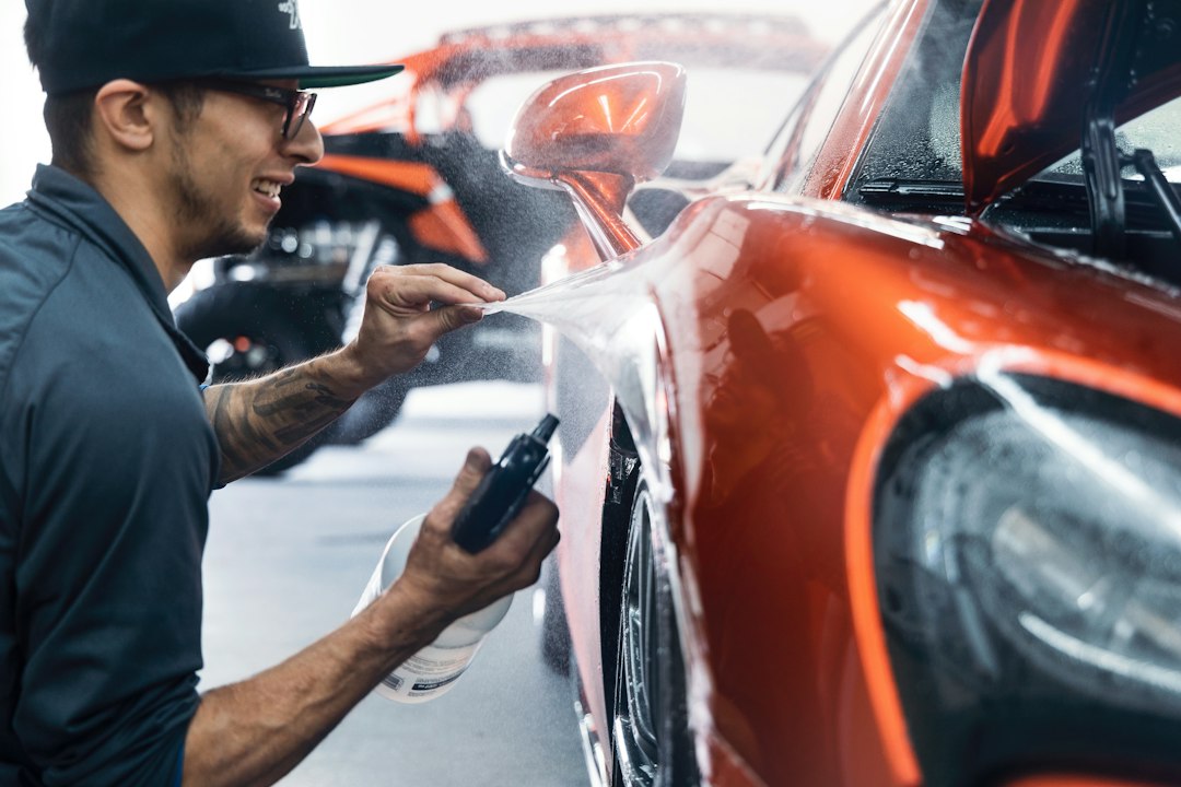 Technician applying protective film to a finished performance vehicle